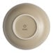 A white porcelain bowl with a sand dollar design on the inside and a white rim with the word Ariane.