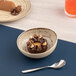 A Tornado Sand Dollar Coupe bowl filled with chocolate dessert topped with nuts and caramel.