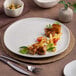An Ariane white porcelain plate with food on it.