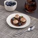 An Ariane Earth porcelain plate with a dessert of chocolate and blueberries.