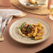 A round rimless porcelain plate with food on it.