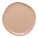 A close-up of an Ariane Earth dark sand porcelain plate with small speckled dots.