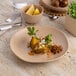 A dark sand dots porcelain plate with food, a fork, and a knife on a table.