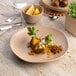 An Ariane Earth porcelain plate with food on a table.