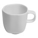 A close-up of a white Ariane porcelain espresso cup with a handle.