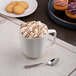 A warm white porcelain espresso cup filled with hot chocolate and marshmallows.