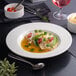 A white round embossed wide rim deep porcelain plate.