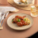 A plate of food with a knife and fork on a table.