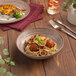 A plate of spaghetti with meatballs and sauce on a Ariane Tornado deep coupe porcelain plate on a table.