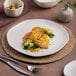 An Ariane Earth porcelain plate with food on a table.