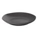 An Ariane charcoal grey porcelain plate with black dots on a white background.