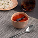 An Ariane dark sand dots porcelain bowl filled with soup and a plate of rice.