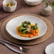 A white Ariane Earth porcelain plate with broccoli and carrots on it.