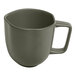 A mist green porcelain cup with grey dots and a handle.