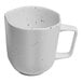 A white porcelain mug with black specks.