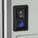 A close-up of the power switch and indicator light on an Avantco Ice Diamond EMC-H-530-A modular half cube ice machine.