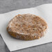 A round, plant-based shiitake mushroom burger patty on a piece of parchment paper.