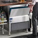 An undercounter air-cooled ice machine with a stainless steel exterior and a front-opening bin.