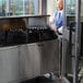 A black laminate and stainless steel electric portable back bar with two locking storage compartments and a raised serving area.