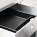 A stainless steel equipment stand with an open drawer and a black interior tray.