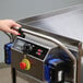 A heavy-duty three-shelf electric utility cart with a control panel and emergency stop button.