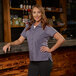A women's gray short sleeve work shirt with button front and chest pockets.