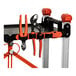 A foldable jobsite cart with three shelves, shown holding various hand tools on its side.