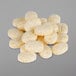 A pile of yellow and white speckled oval granules used as coffee and espresso grinder cleaner.