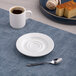 A white round embossed porcelain espresso cup saucer with a wide rim.