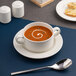 A white round embossed porcelain soup bowl saucer with a wide rim.