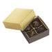 A small gold two-piece candy box with four chocolate candies inside.