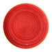 A round, rimless red porcelain plate with a subtle swirl pattern.