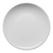 A round, warm white porcelain coupe plate with a slanted edge.
