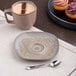 A gold and brown organic round porcelain saucer with a textured finish.