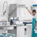 A commercial Hobart high temperature door-style electric dishwasher with a booster heater in a kitchen setting.