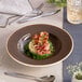 A round, wide rim deep porcelain plate in a mokka color.