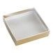 A small, square gold candy box with a transparent lid.