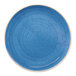 A round, blue, rimless porcelain plate with a speckled design.