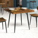 A square mid-century style dining table with a wooden top and black metal legs.