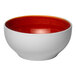 A round porcelain bowl with a white exterior and a red interior.