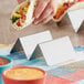 A stainless steel taco holder with two compartments for holding tacos upright.