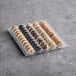 A plastic tray containing an assortment of coffee-flavored macarons.