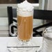 An 8 oz. glass Irish coffee mug filled with coffee and topped with whipped cream.