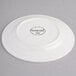 A white porcelain plate with a wide rim, shown upside down to display the Syracuse China branding and model information on the bottom.