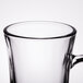 A clear glass coffee mug with a handle.