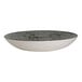A round, shallow coupe bowl with a speckled gray interior and a smooth white exterior.