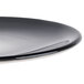 A black porcelain coupe plate with a smooth, glossy finish.