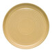 A tan terracotta plate with a circular, ridged design.
