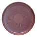 A round mauve terracotta plate with concentric circular patterns.
