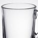 A clear glass coffee mug with a handle.